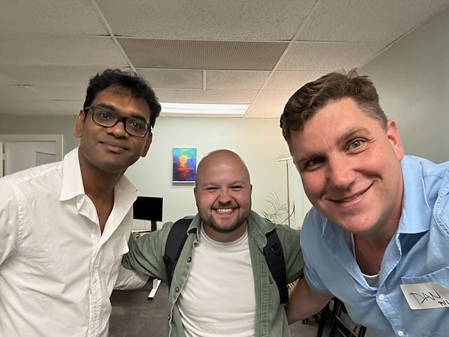 Three people smiling together at the May AI Builders Meetup