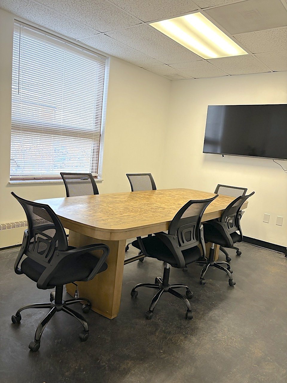 Conference room with a table for six to eight and a wall-mounted Smart TV