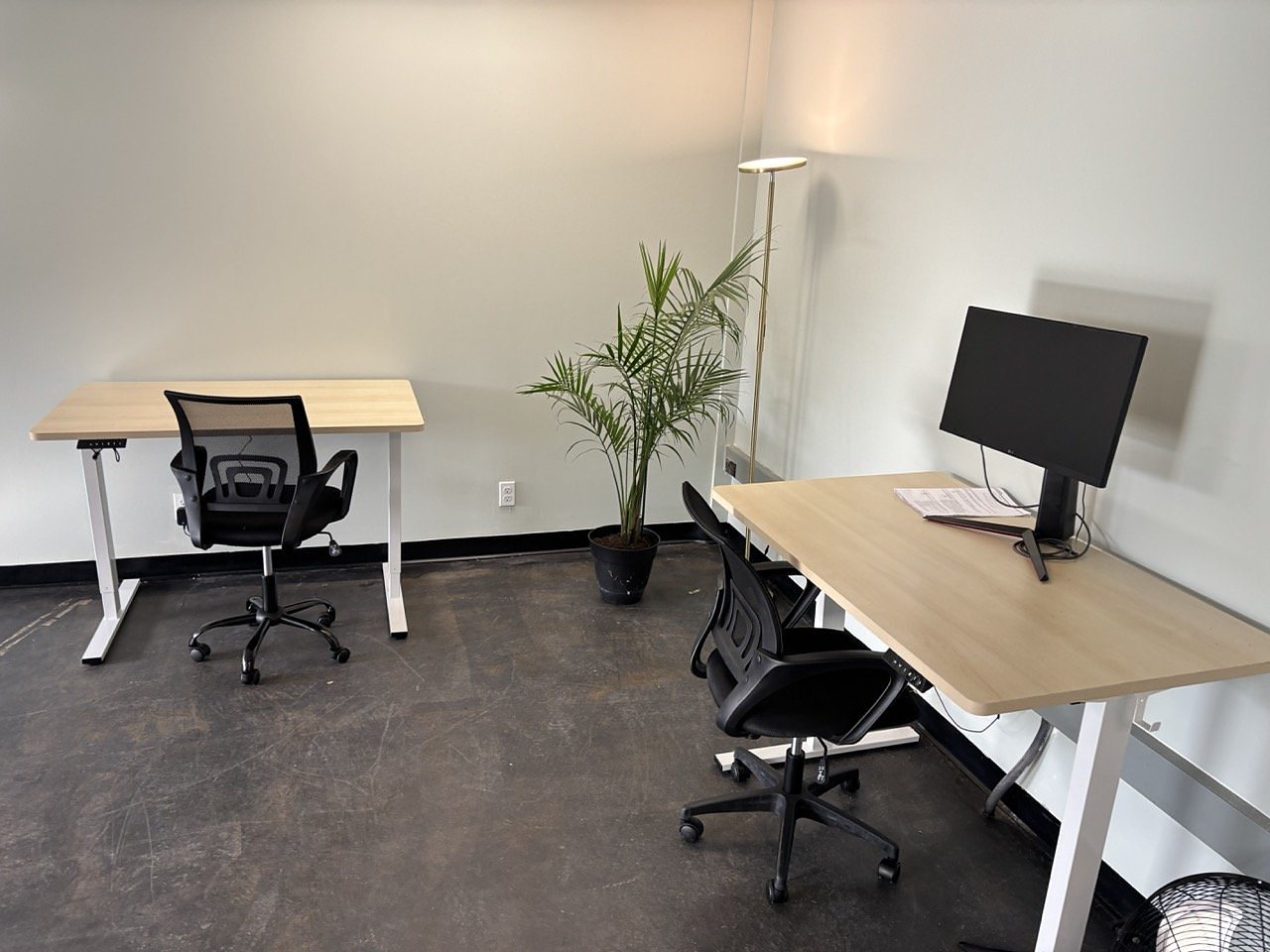 Two electric sit-stand desks with ergonomic chairs and an external monitor